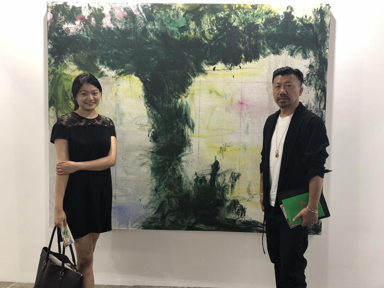 コレクターの劉江山(右)と張恩利の作品の前で